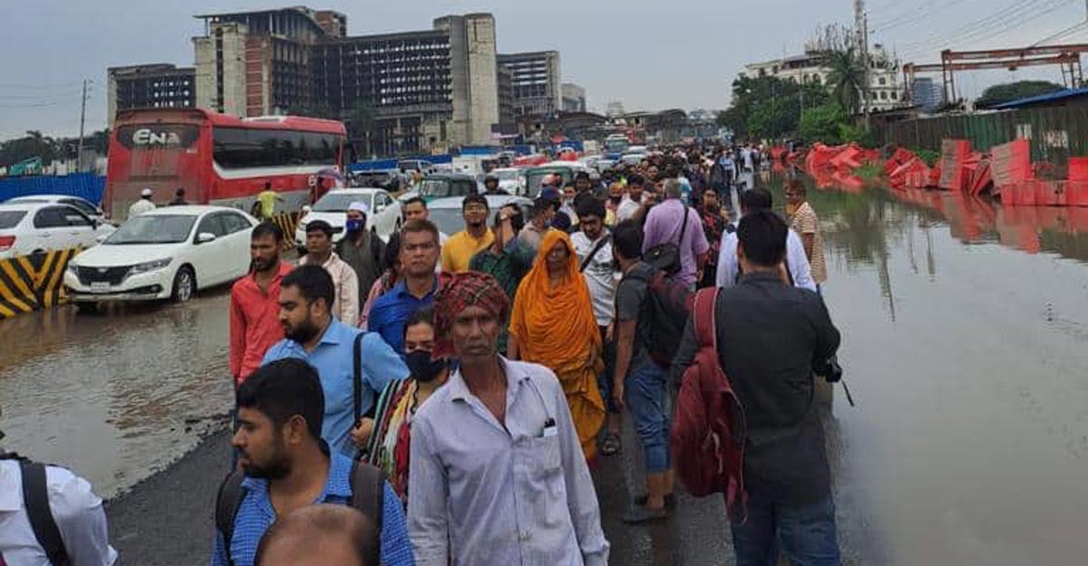 উত্তরায় মোটর বসিয়ে সড়কে জমা পানি সরাচ্ছে পুলিশ