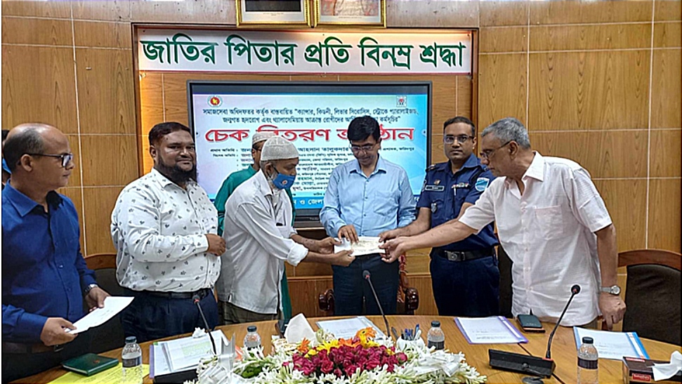 ফরিদপুরে সমাজসেবা বিভাগের পক্ষ থেকে অসুস্থদের মাঝে চেক বিতরণ করছে
